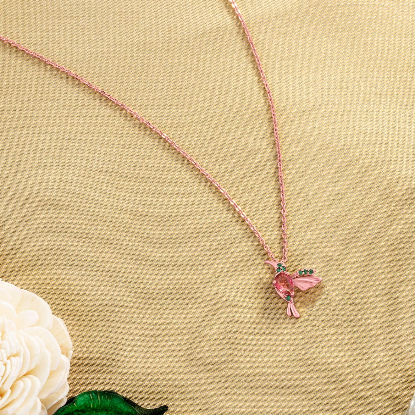 rose gold necklace with a pink bird pendant