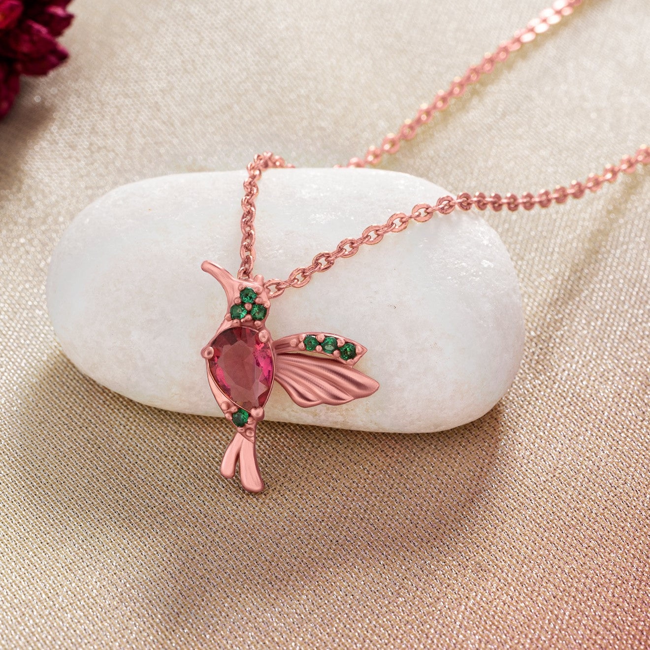 rose gold necklace with a pink bird pendant