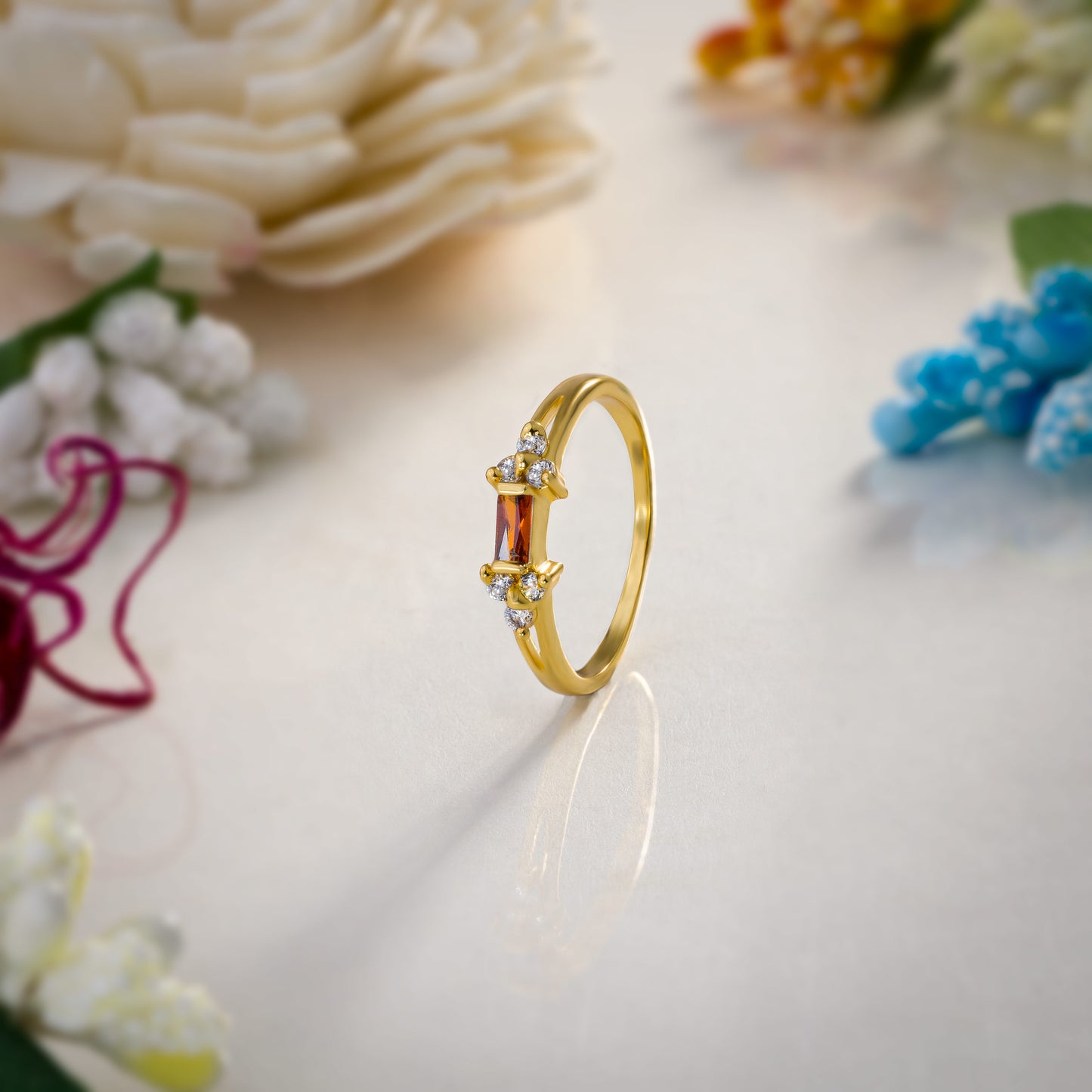 golden ring with a stone and two white diamonds