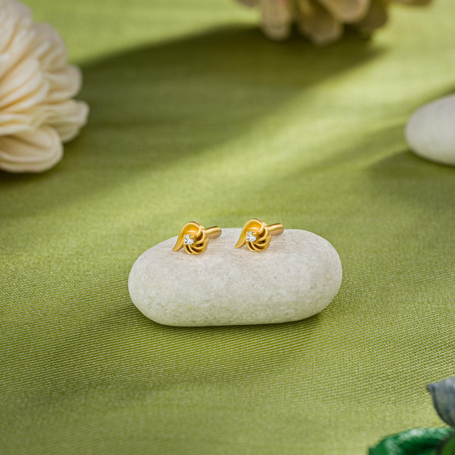 pair of golden earrings with a stone