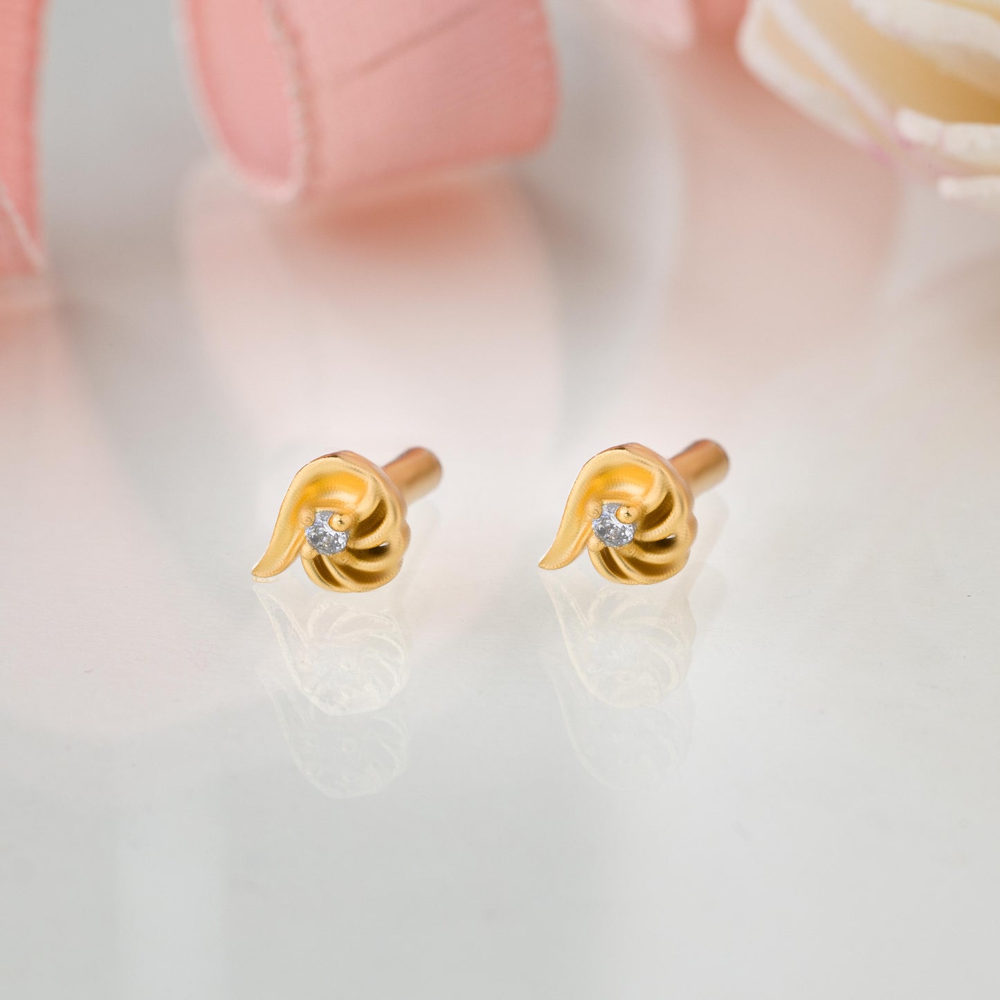 pair of golden earrings with a stone