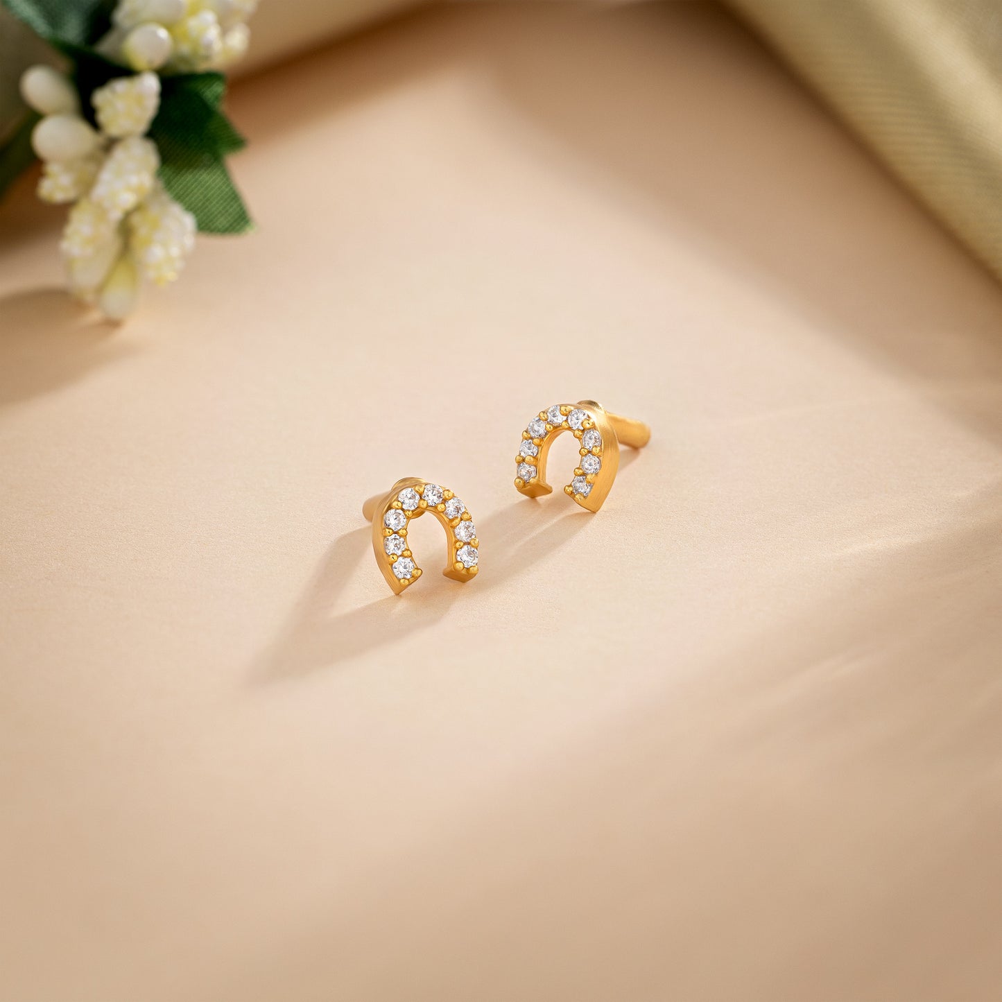 pair of golden earrings with white diamonds