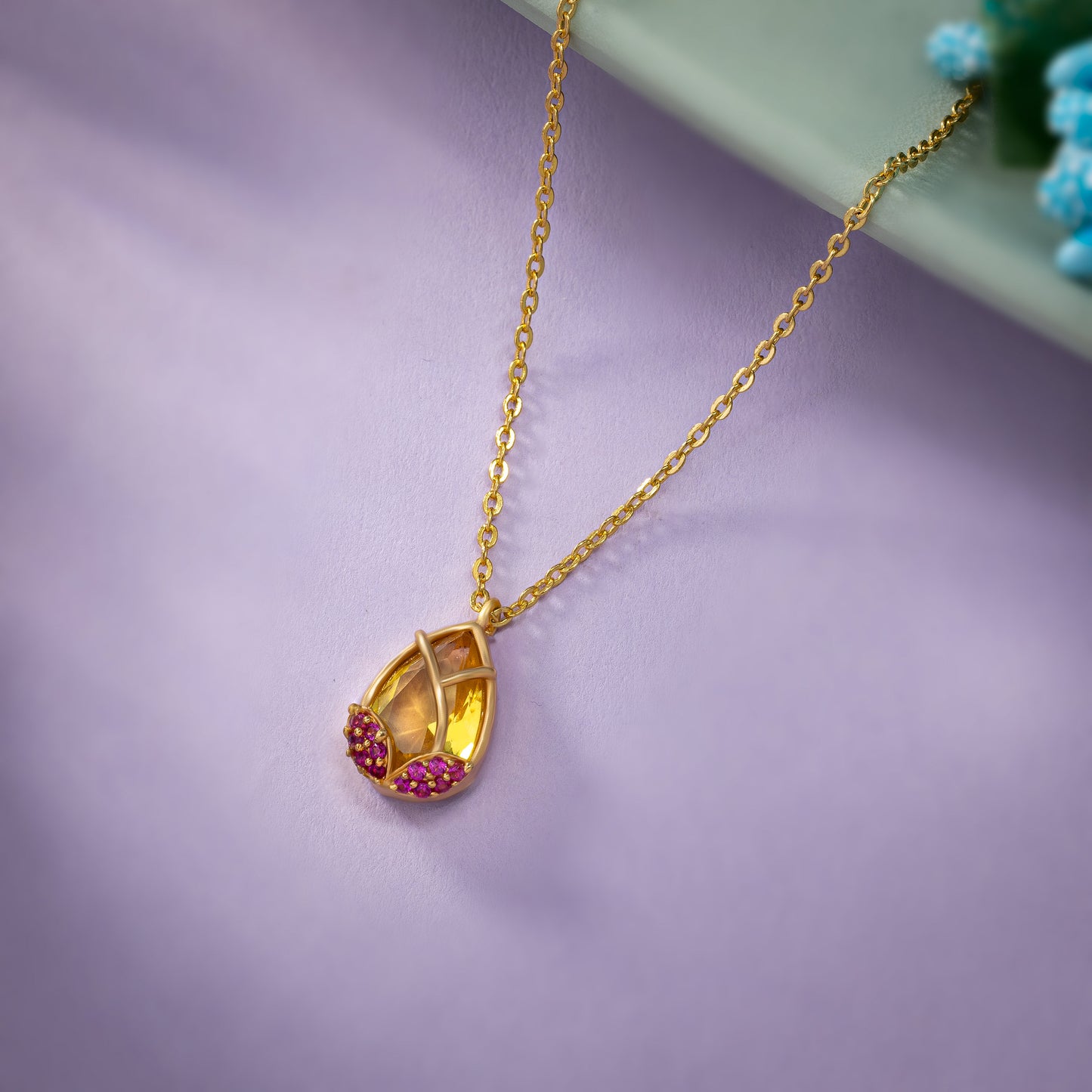 golden necklace with a large tear shaped pendant