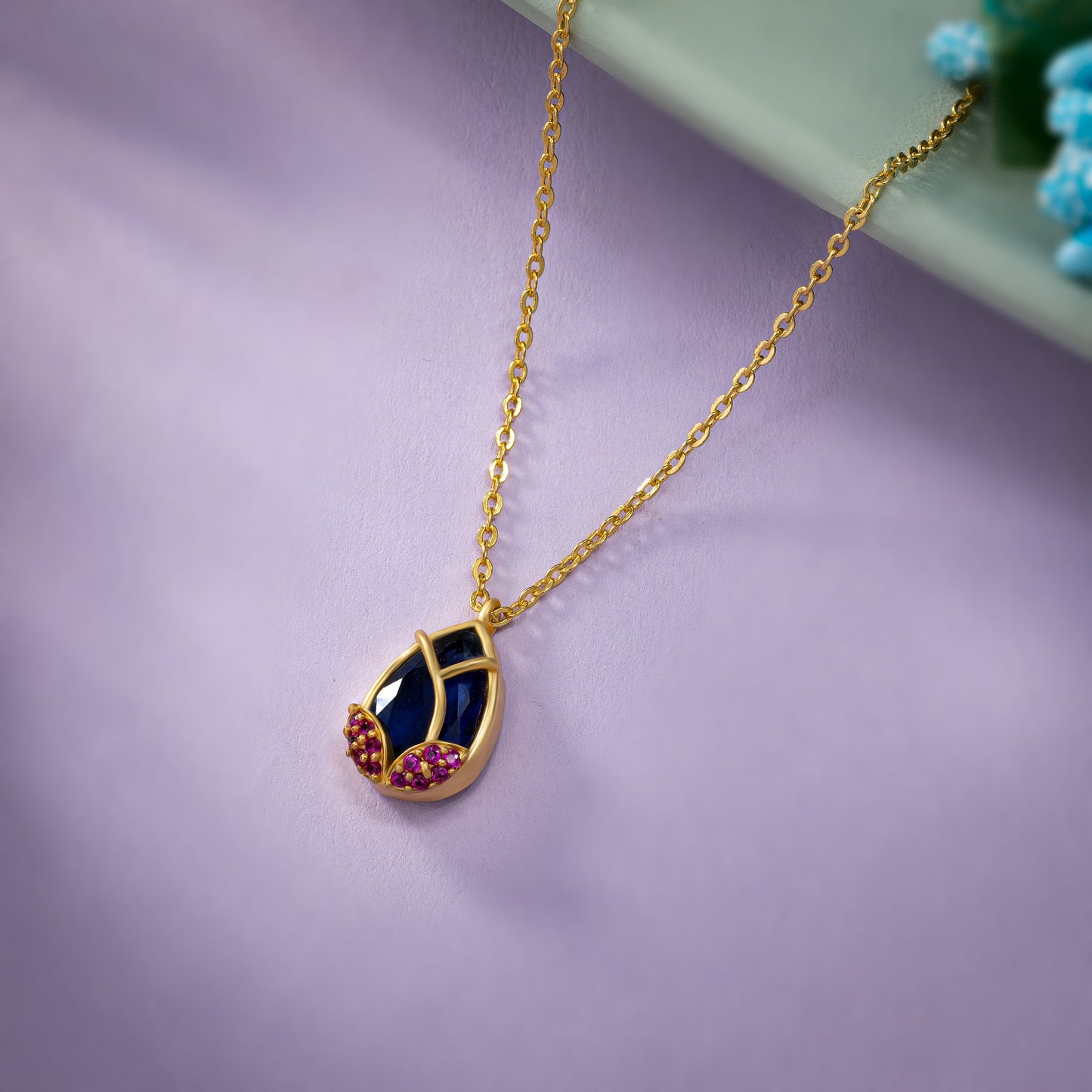 golden necklace with a large tear shaped pendant