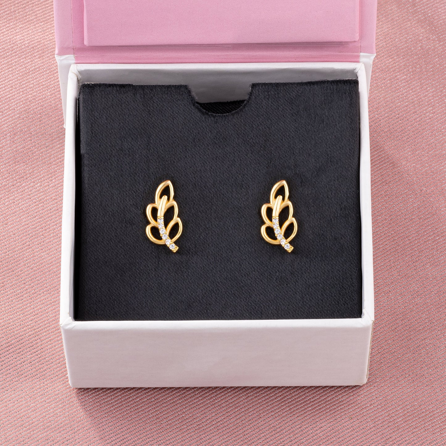 pair of golden earrings with a single diamond