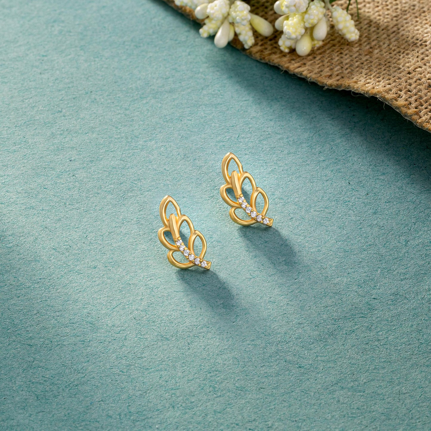 pair of golden earrings with a single diamond