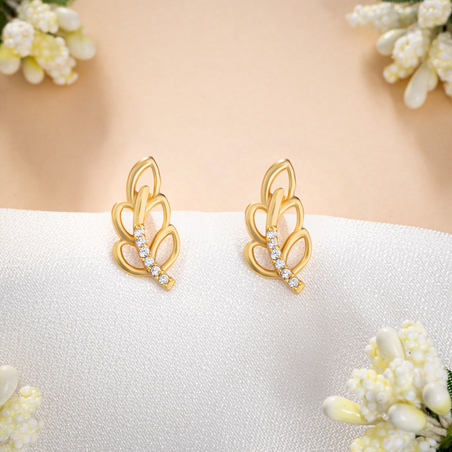 pair of golden earrings with a single diamond