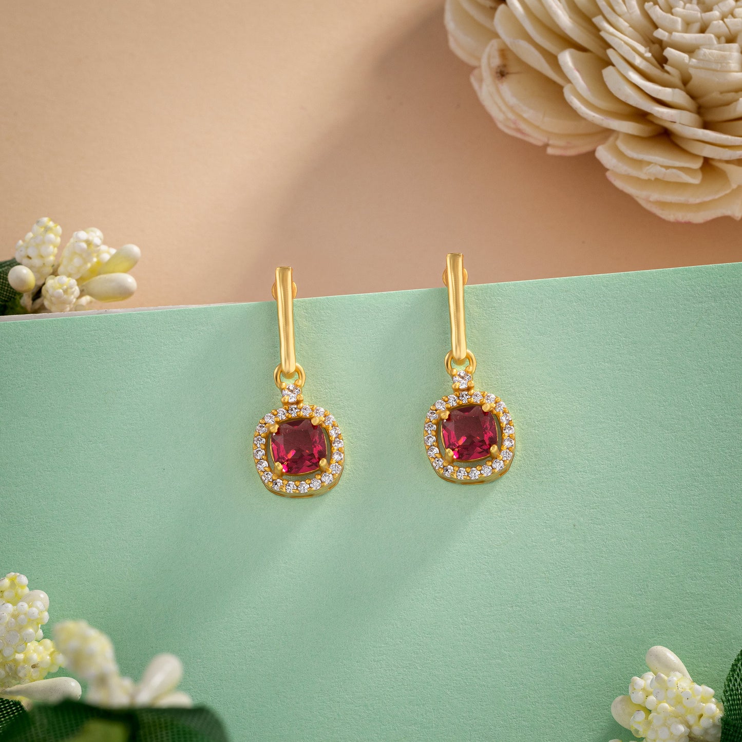 pair of earrings with a ruby stone and diamonds