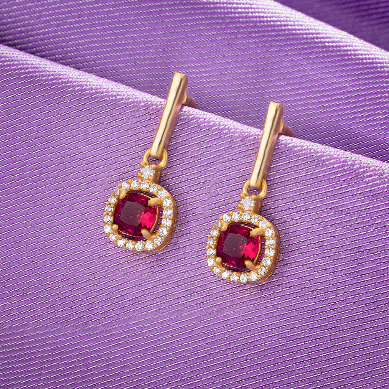 pair of earrings with a ruby stone and diamonds