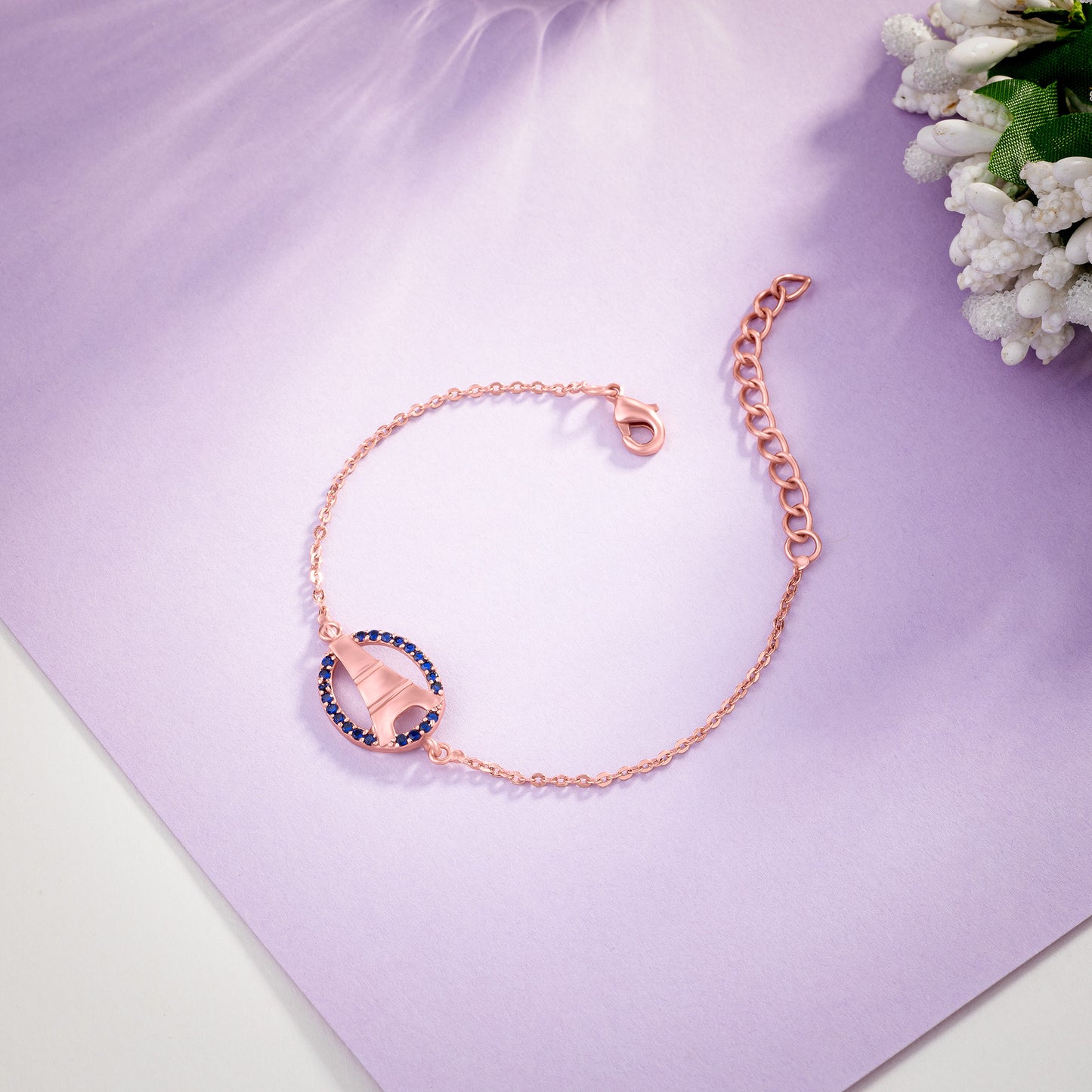 rose gold bracelet with a white stone and a rose gold crystal