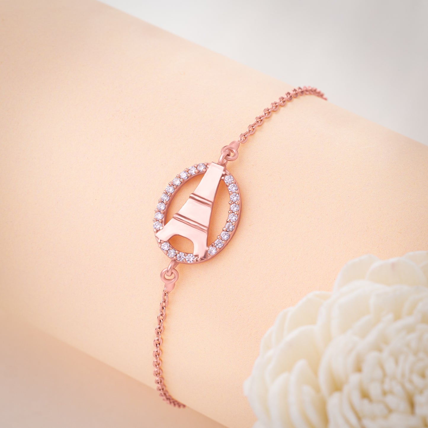 rose gold bracelet with a white stone and a rose gold crystal