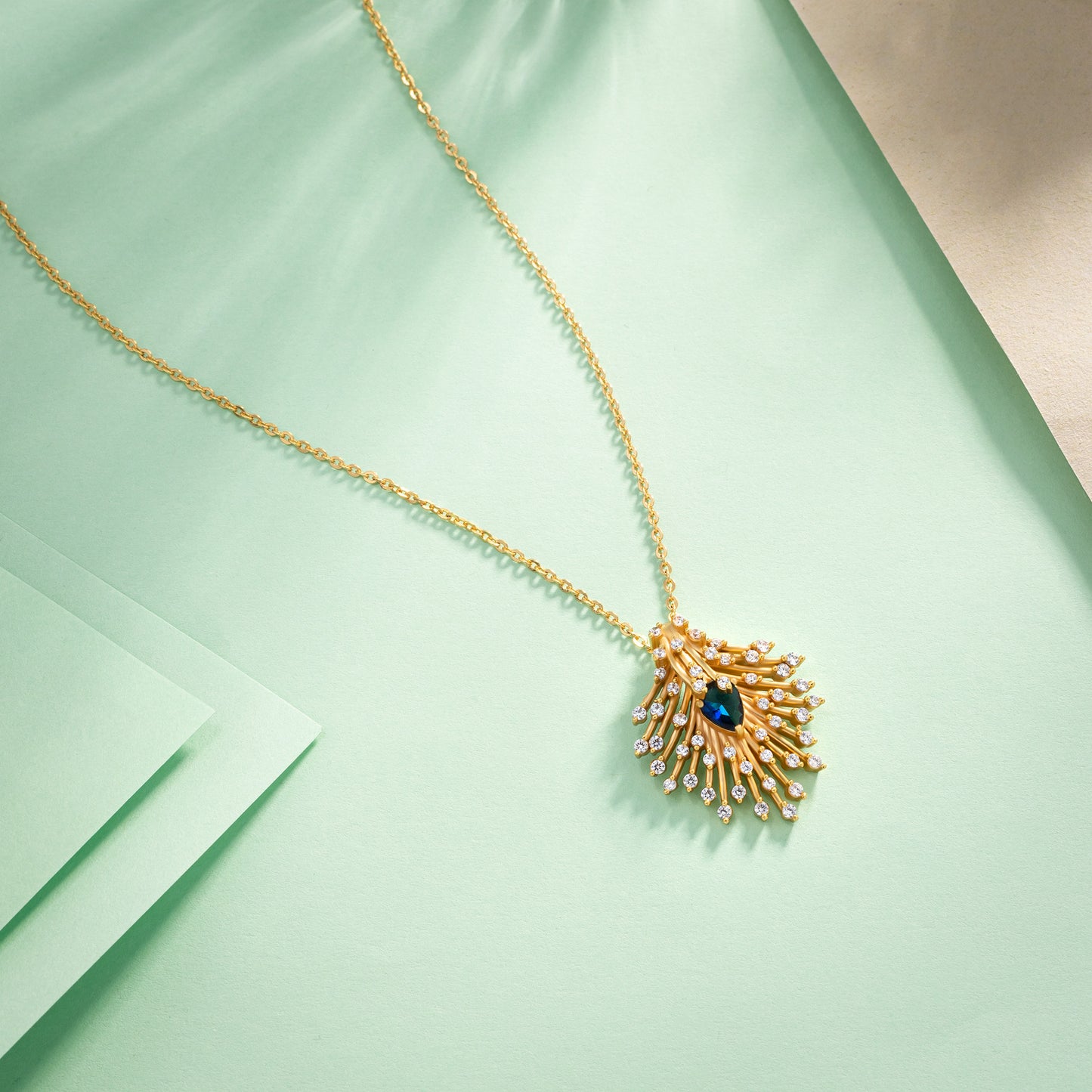 golden necklace with a blue stone pendant