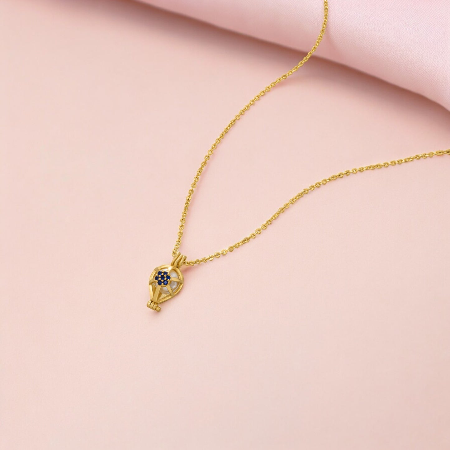 golden necklace with a blue sapphire stone