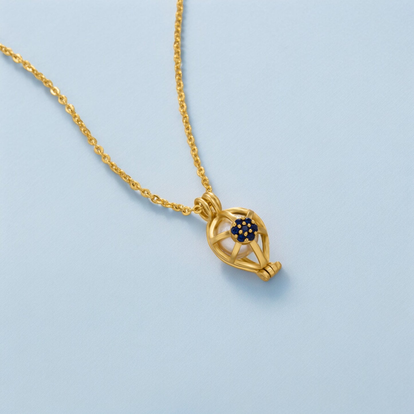 golden necklace with a blue sapphire stone