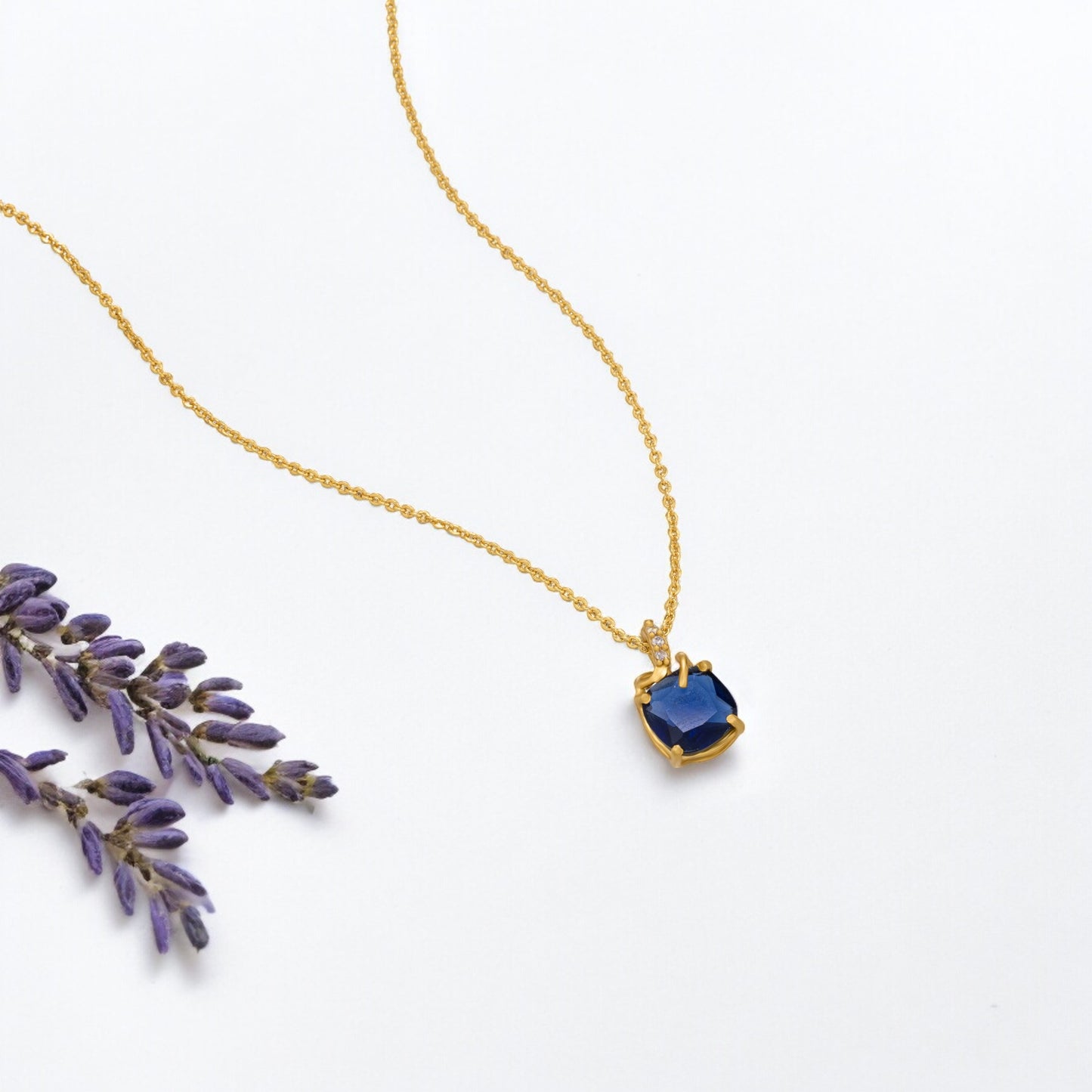 golden necklace with a sapphire stone