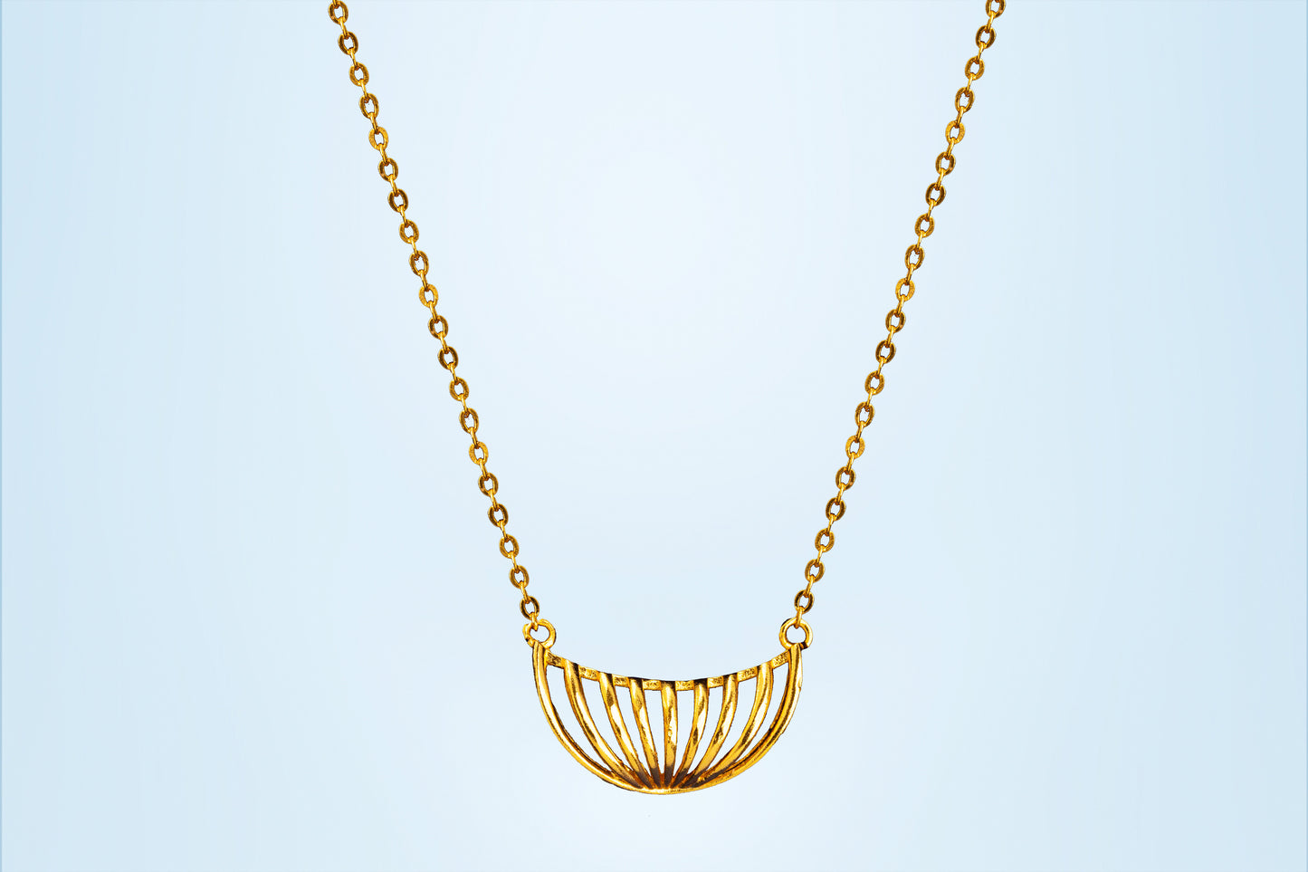 golden necklace with a large curved design