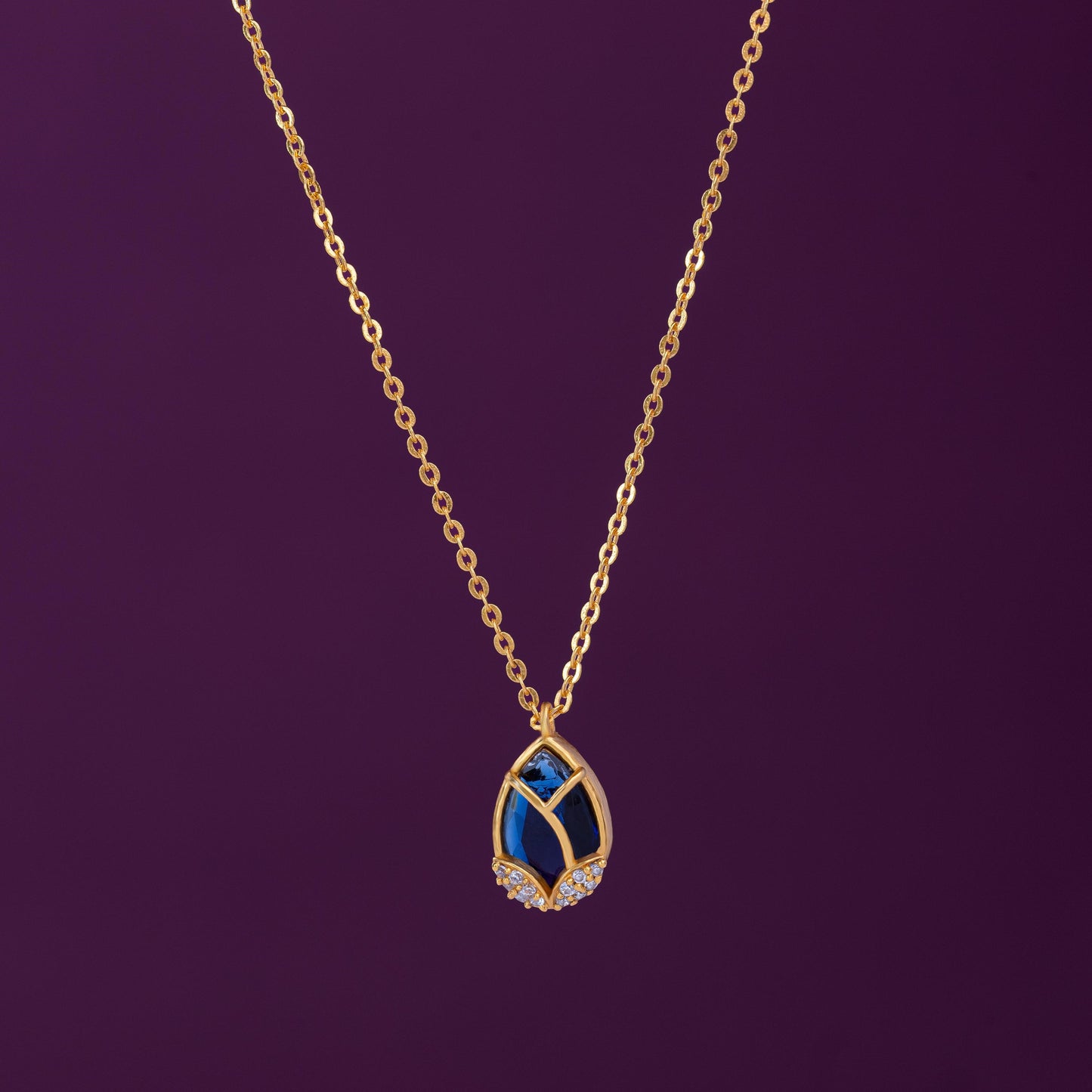 golden necklace with a large tear shaped pendant