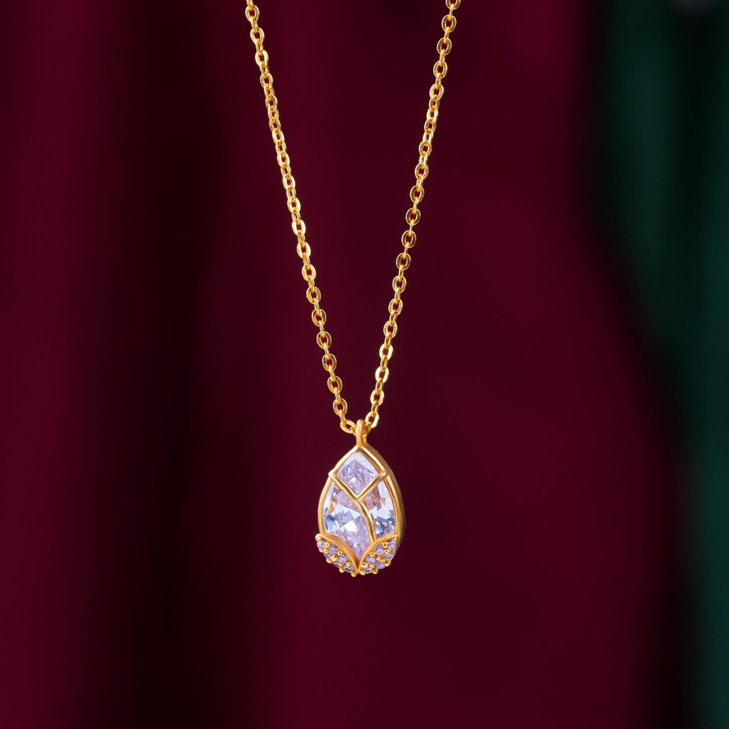 golden necklace with a large tear shaped pendant