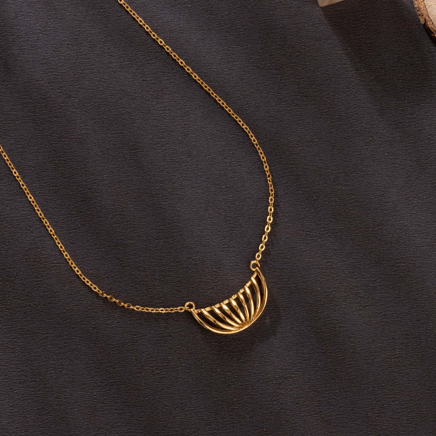 golden necklace with a large curved design