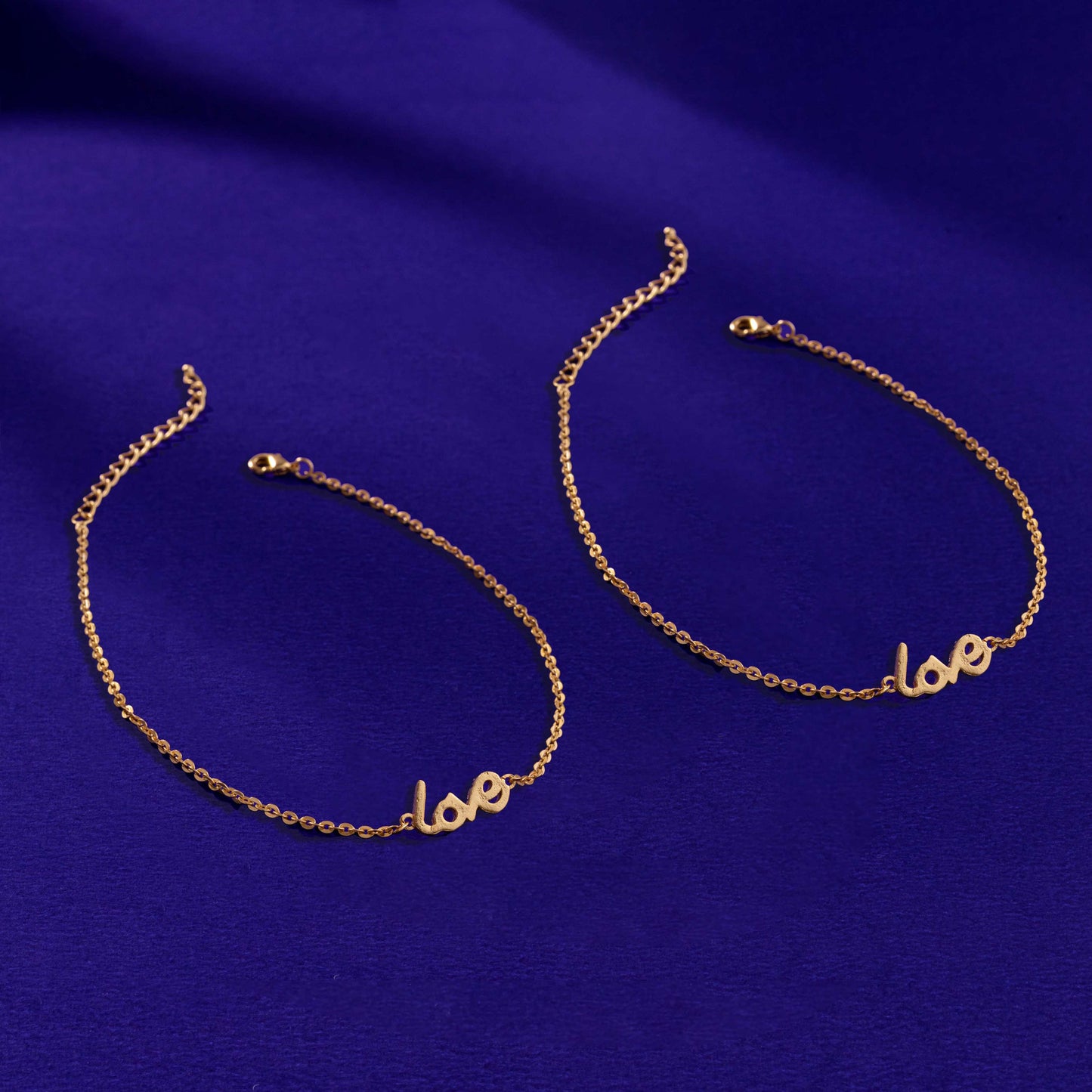 pair of golden anklet with the word love