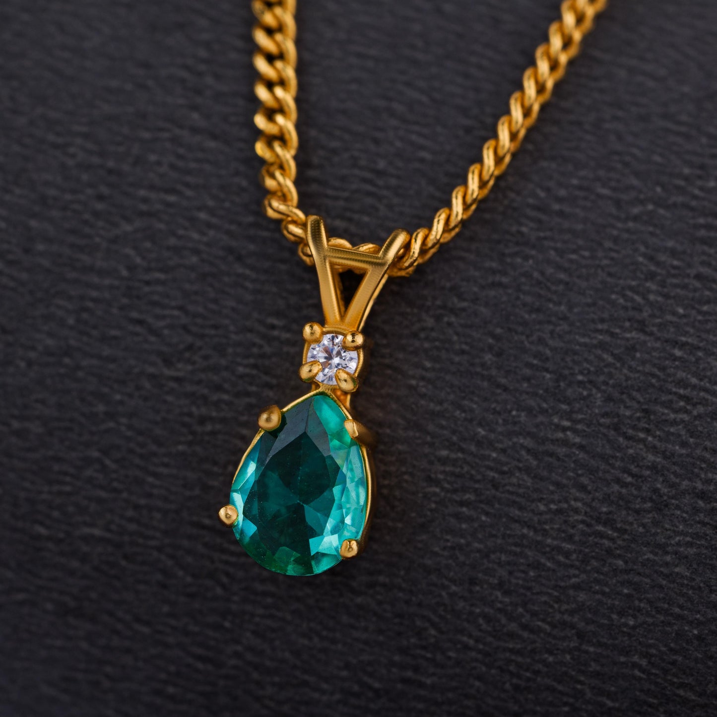 golden necklace with a emerald stone