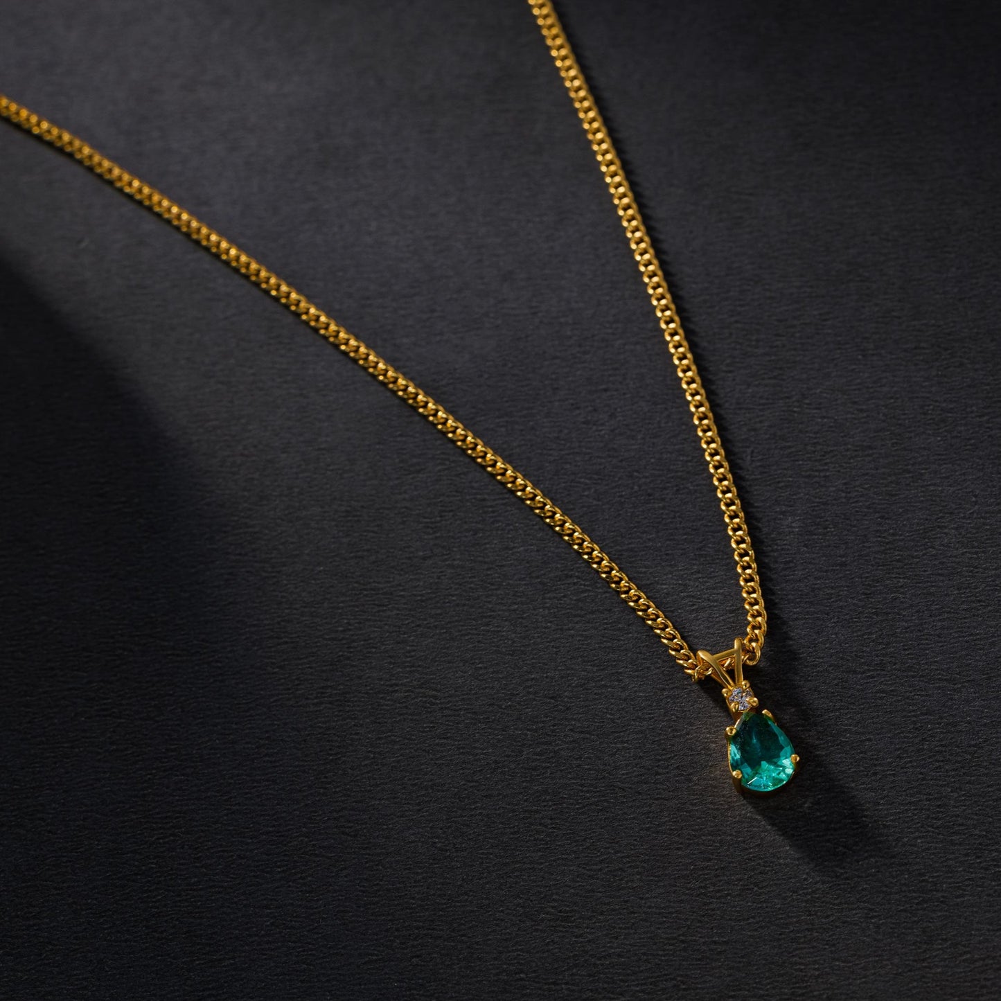 golden necklace with a emerald stone