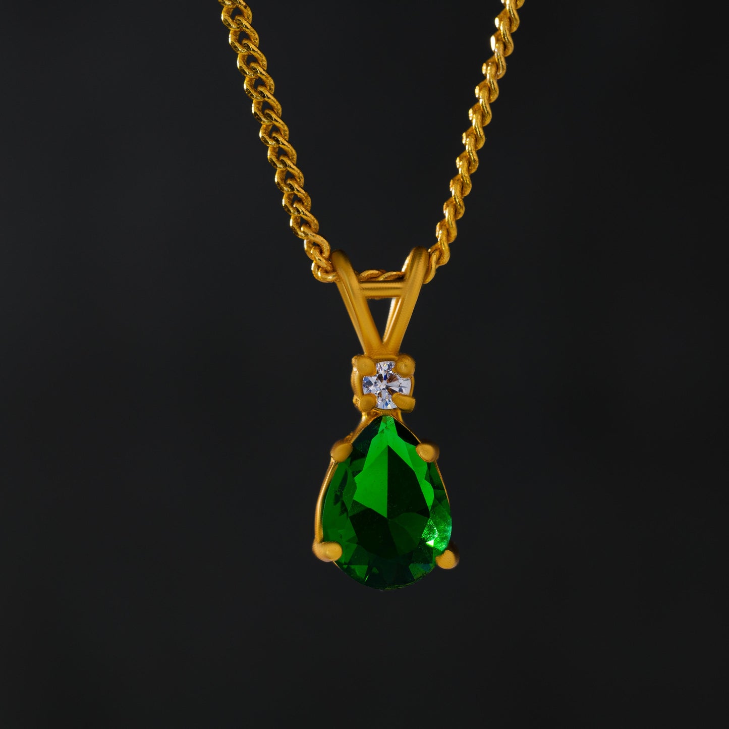 golden necklace with a emerald stone