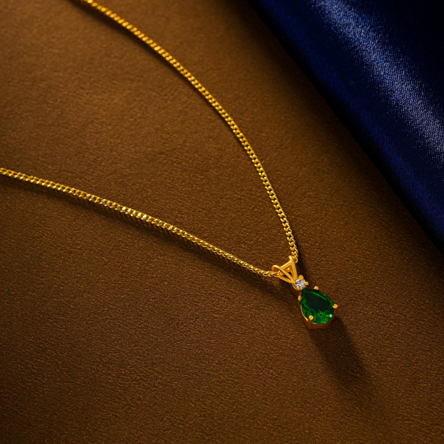 golden necklace with a emerald stone