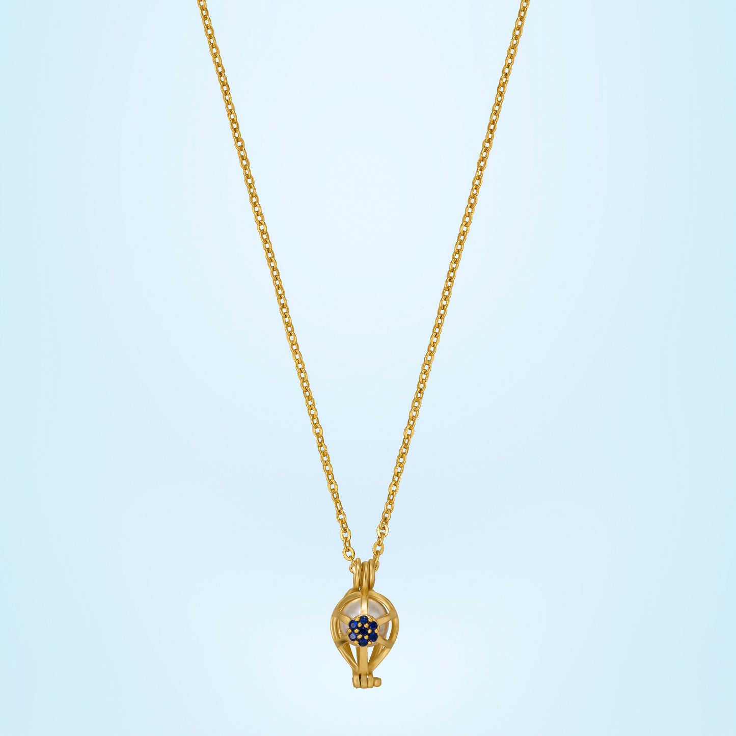 golden necklace with a blue sapphire stone