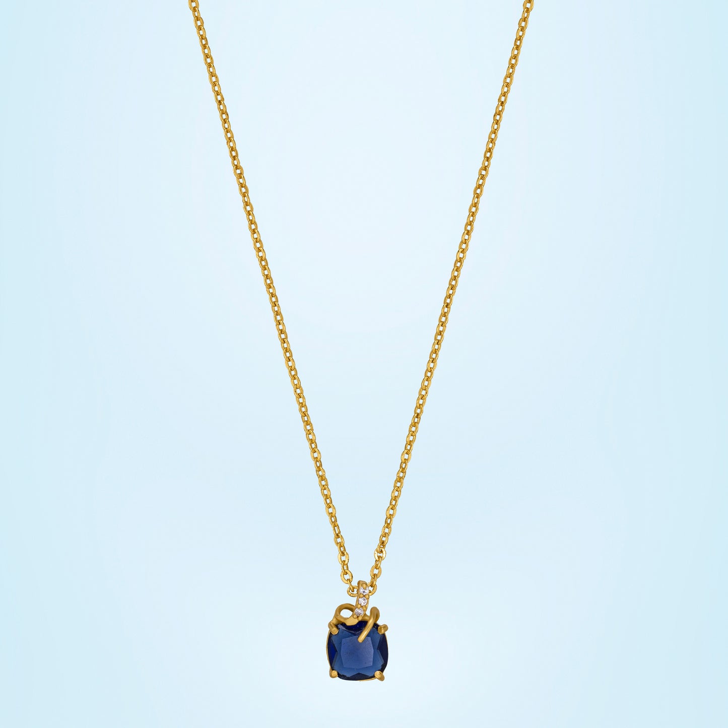 golden necklace with a sapphire stone