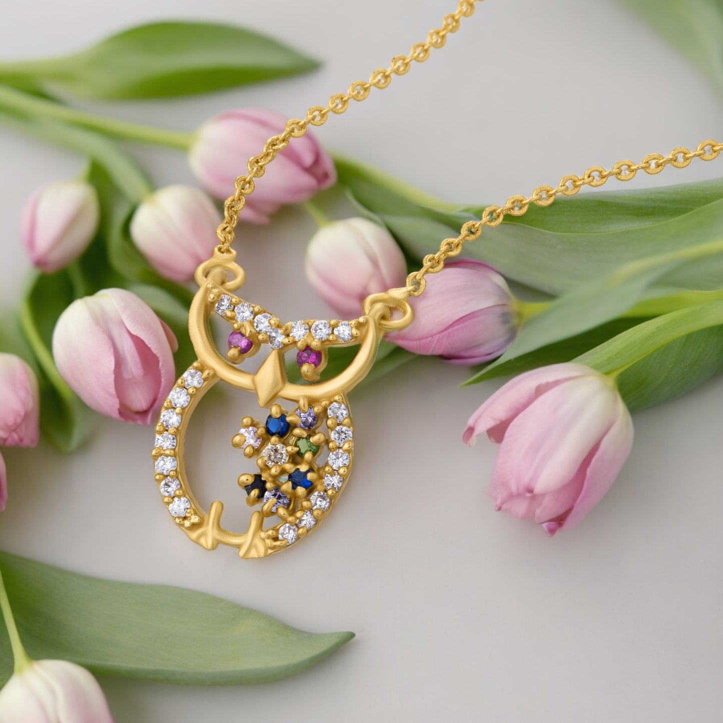 golden necklace with a diamond and emerald stone