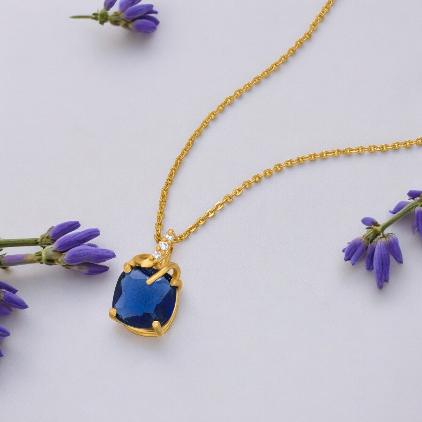 golden necklace with a sapphire stone